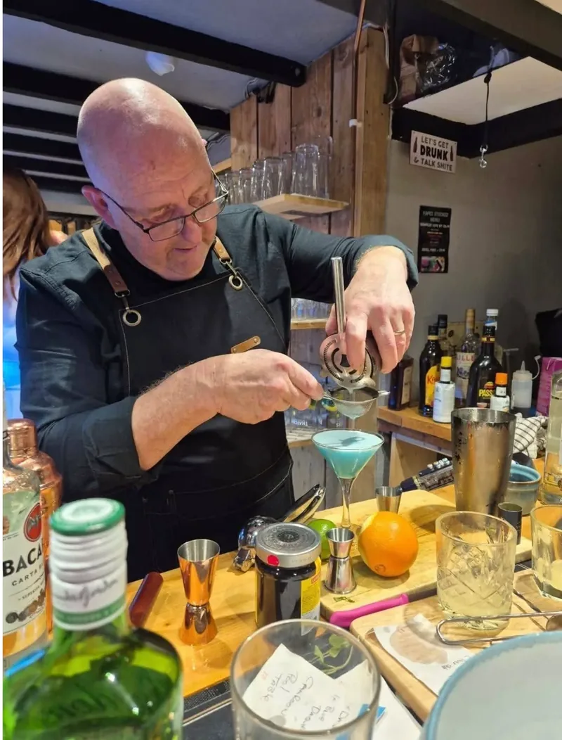 A member of the team mixing cocktails behind the bar during a cocktail night