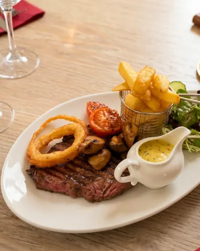 Rump steak with chips, onion rings, tomatoes on the vine, mushrooms and side salad