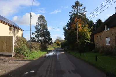 A narrow lane between cottages and trees in the village