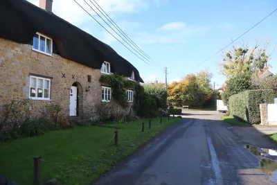 A thatched stone cottage on a quiet village lane