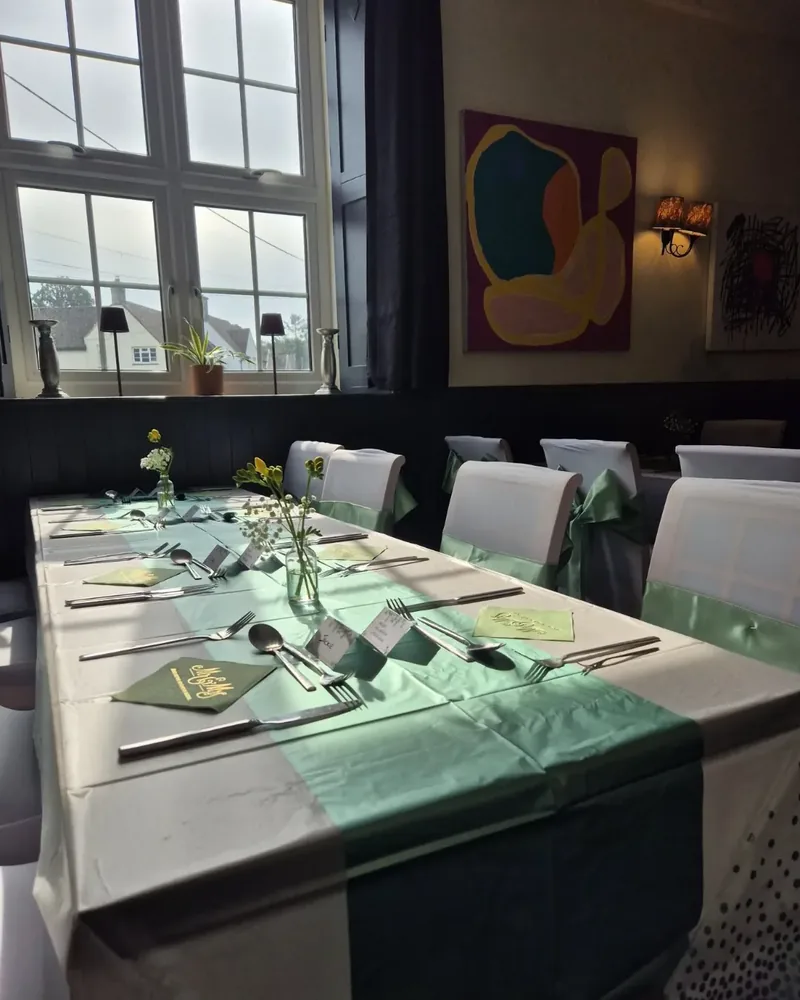 A long table laid up with flowers and napkins in the pub's dining room