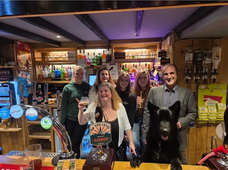 The team behind the bar with Loki the pub dog