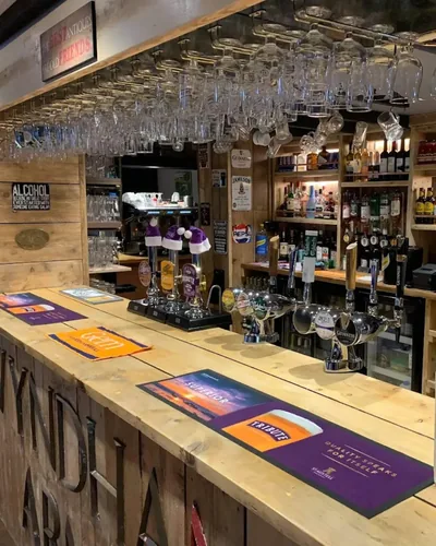 The bar at The Wyndham Arms, with hand pumps and glasses above the counter